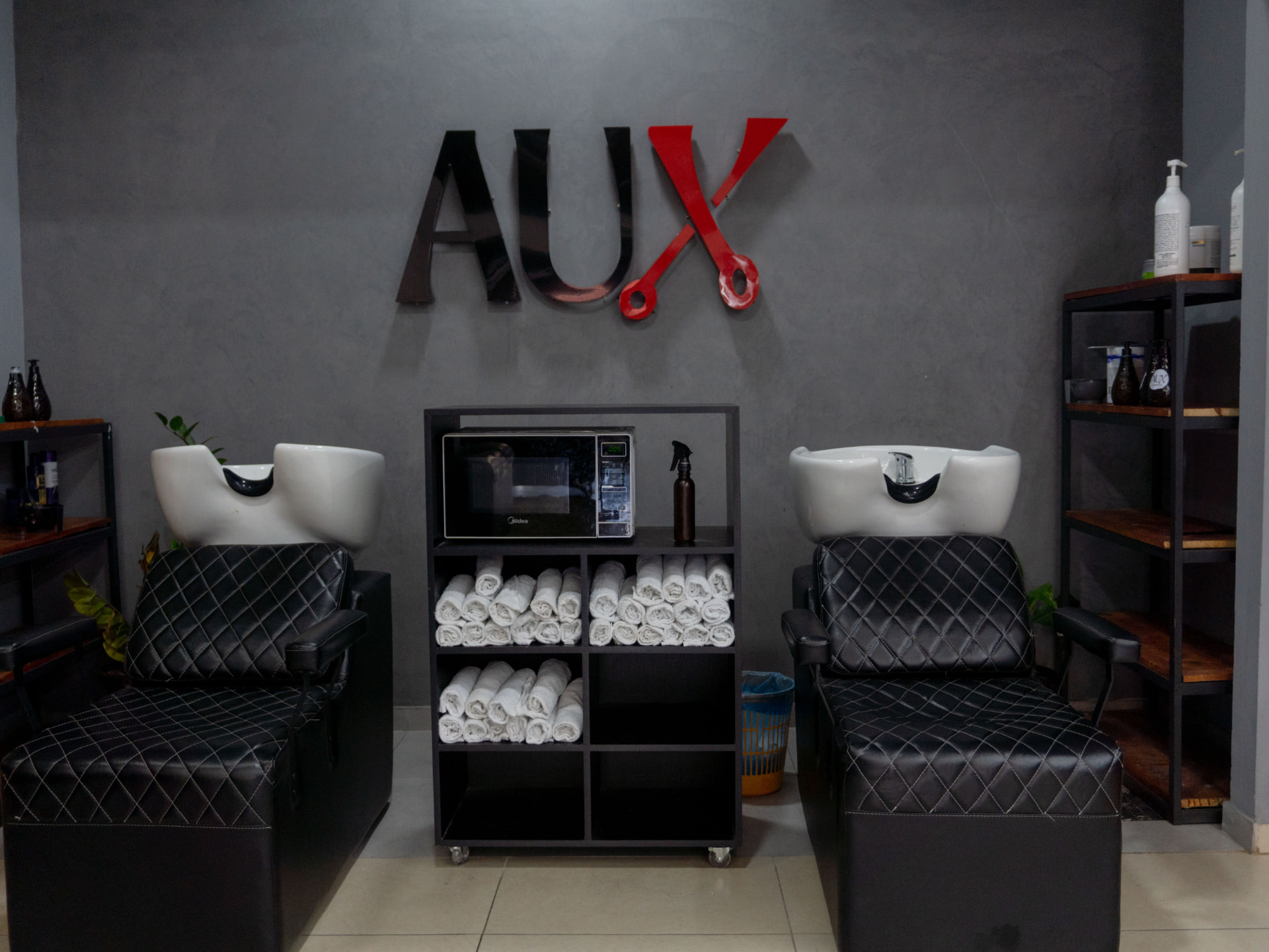 Ambiente da AUX Barbearia com iluminação sofisticada